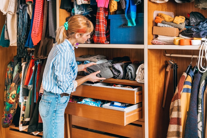 Woman neatly organizing items in closet